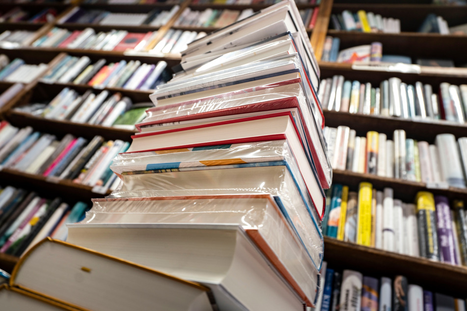Ein Stapel neuer Bücher liegt auf einem Verkaufstisch in einer Buchhandlung.