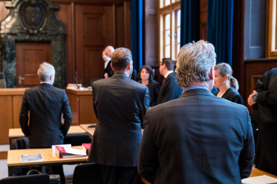 Drei von sechs angeklagten Beamten im Sitzungssaal des Landgerichts Nürnberg-Fürth.