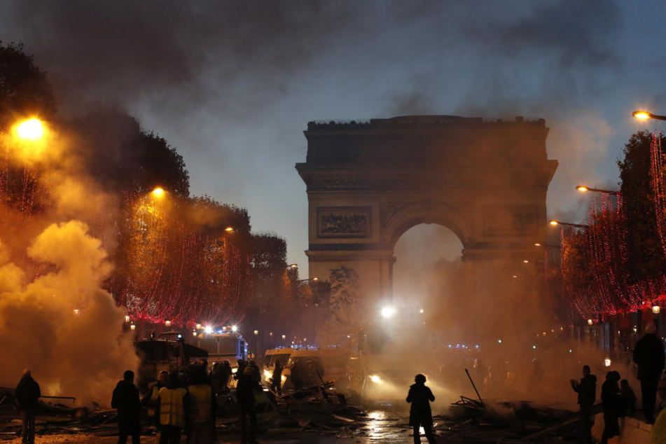 Rauch steigt während eines Protestes gegen die Erhöhung der Kraftstoffsteuern auf der Champs-Elysees-Allee auf.