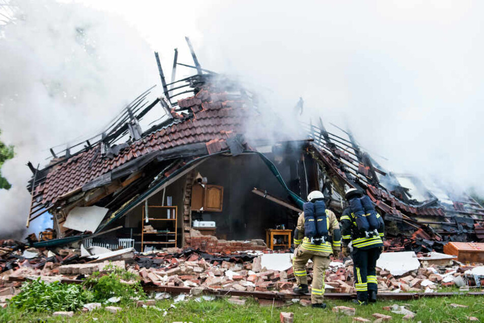 Feuerwehrleute stehen vor den Trümmern des Hauses in Wohltorf.