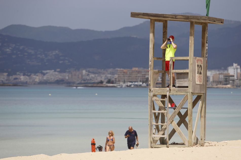 :Ein Rettungsschwimmer beobachtet den Strand von Arenal. Am Ballermann nehmen die Rettungsschwimmer am Samstag ihre Arbeit wieder auf. (Zu dpa «Vorsichtiger Start der Badesaison am Ballermann»)