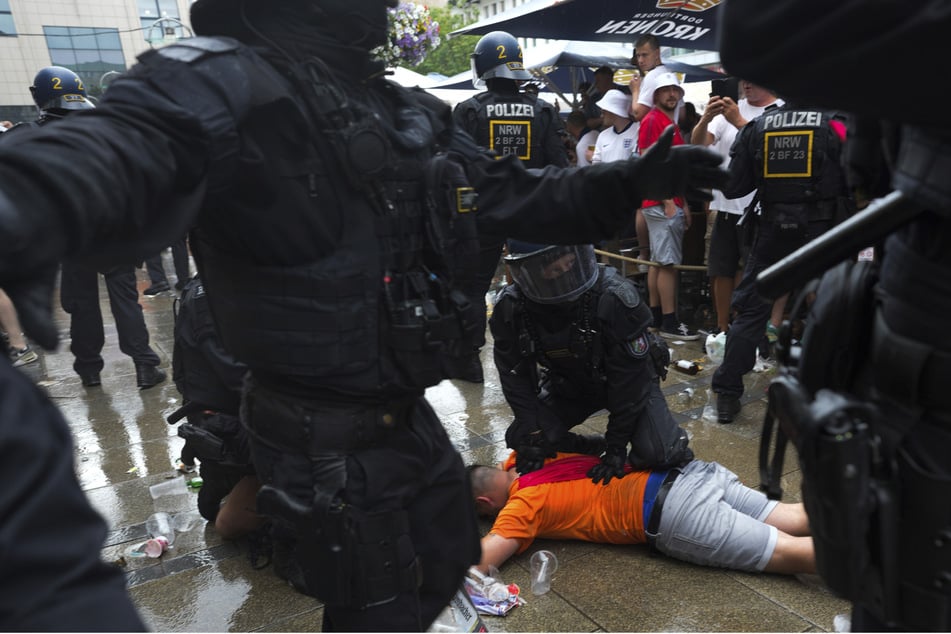 Randale in der Dortmunder Innenstadt! Polizeibeamte halten einen Fußballfan fest.