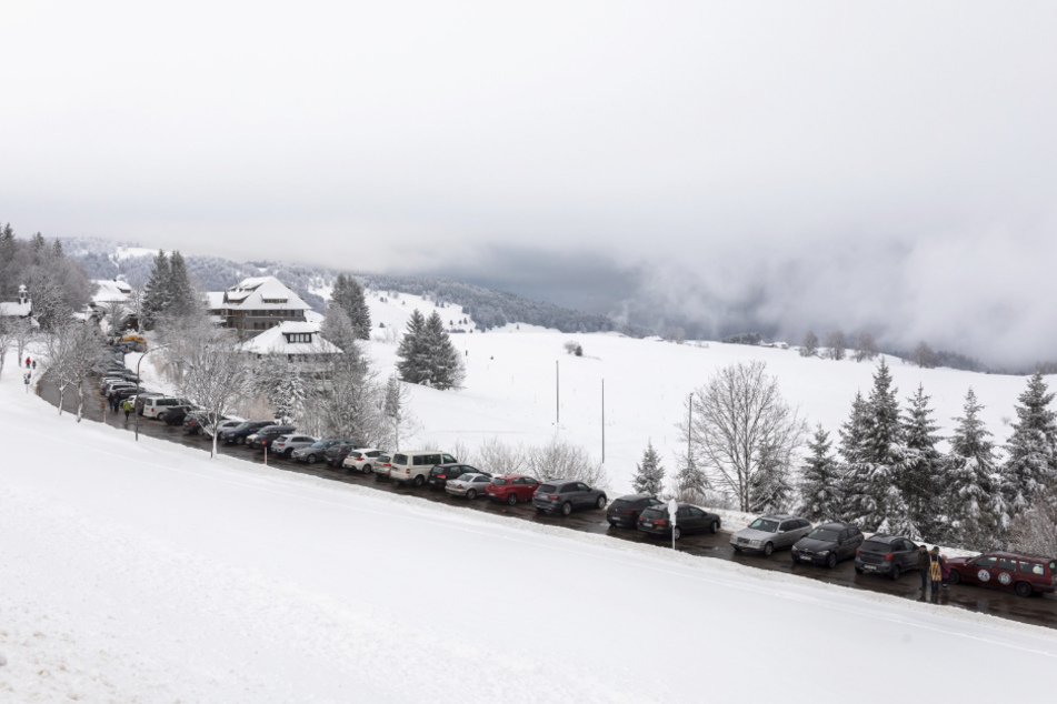 Autos von Tagestouristen stehen nahe der Halde auf einem Parkplatz. Das winterliche Wetter in den oberen Lagen des Schwarzwalds lockt an Neujahr viele Besucher an.