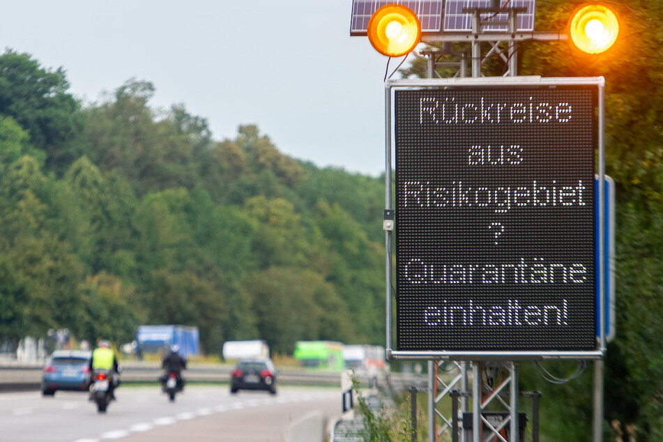 Auf der Autobahn A7 werden Reisende aus Risikogebieten mit einer Leuchttafel "Rückreise aus Risikogebiet? Quarantäne einhalten!" auf die notwendigen Maßnahmen hingewiesen.