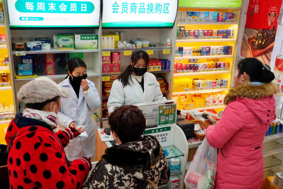 Mitarbeiterinnen verkaufen in einer Apotheke Atemschutzmasken.