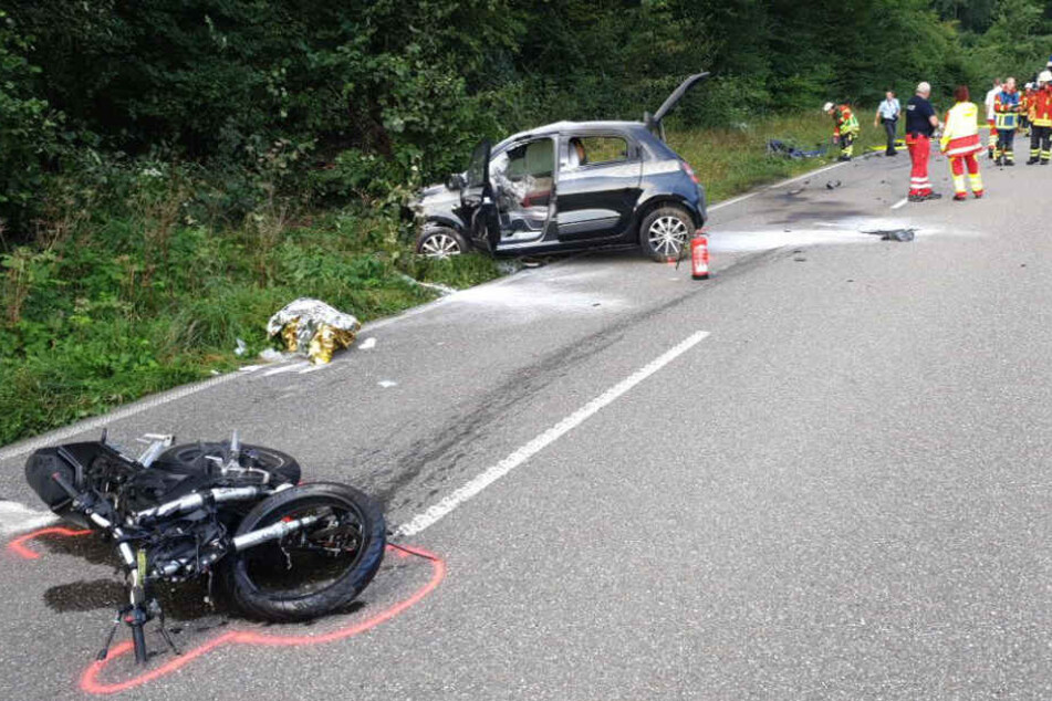 Das Motorrad liegt auf der Straße, im Hintergrund das Auto.