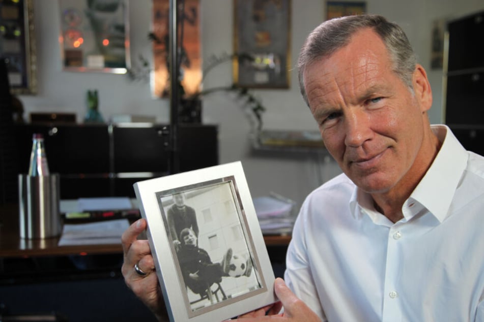 Boxlegende Henry Maske zeigt in einer Szene der Dokumentation "Mythos Plattenbau – Wohnträume aus Beton" ein Foto aus Kindertagen (undatierte Filmszene).