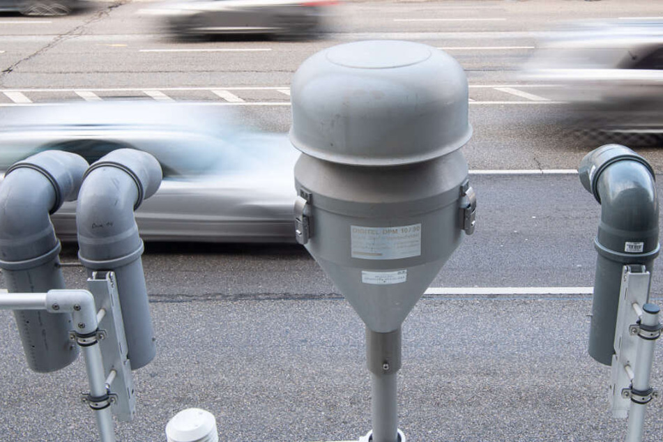 Autos fahren an der Messstation am Neckartor vorbei.