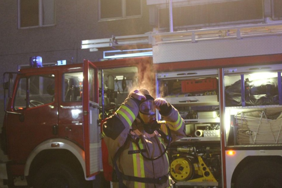Ein Kamerad der Feuerwehr kommt qualmend aus der Brandwohnung. Zum Zeitpunkt des Feuers war darin glücklicherweise keine Person.