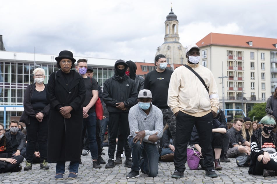 Teilnehmer stehen, knien und sitzen während einer "Silent Demo" zur Erinnerung an den gewaltsamen Tod von George Floyd auf dem Dresdner Altmarkt.