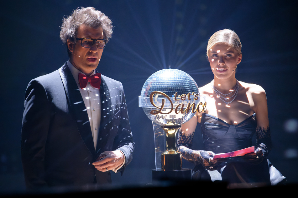 Die Moderatoren Daniel Hartwich und Victoria Swarovski stehen im Finale 2023 neben der Trophäe der RTL-Tanzshow "Let's Dance".