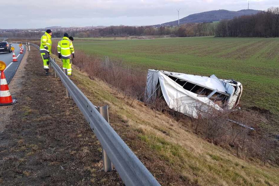 ADAC- Mitarbeiter stehen vor dem verunfallten Fahrzeug.