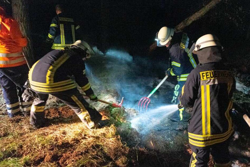 Feuerwehrleute legen Gräben im Moor an.
