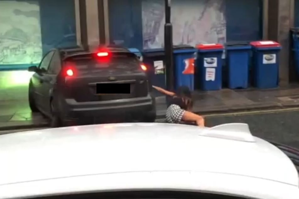 Der Fahrer versucht die Frau scheinbar umzufahren. Dabei stürzt die Frau.