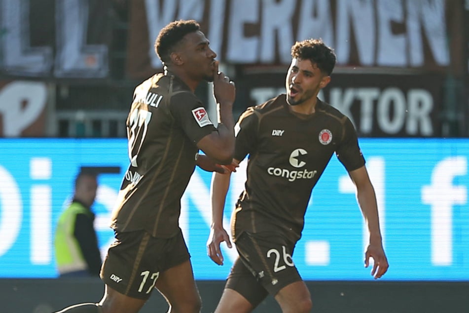 St.-Pauli-Angreifer Oladapo Afolayan (25, l) jubelt nach seinem Treffer provokativ in Richtung der Kieler Fans.