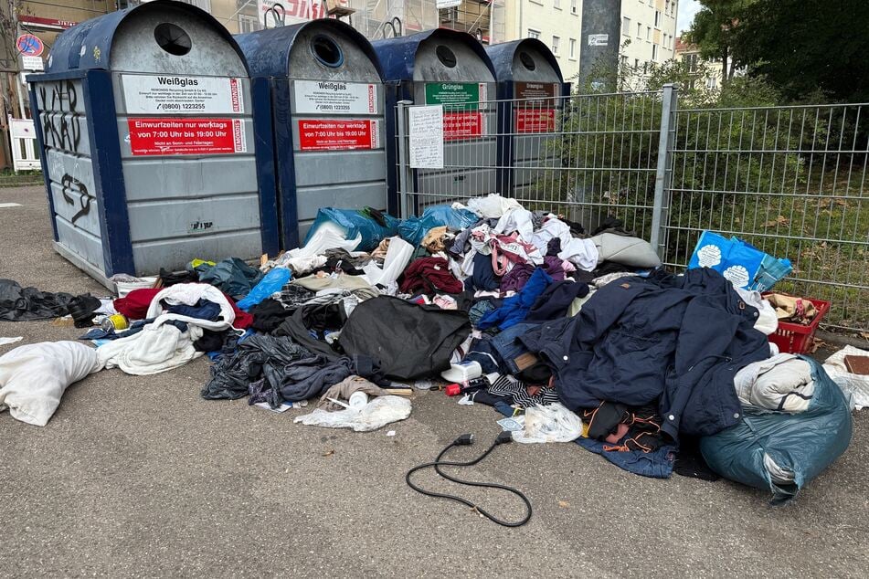 Ein typisches Bild in deutschen Großstädten: Kleidung und anderer Müll liegen vor einem Altglas-Container.