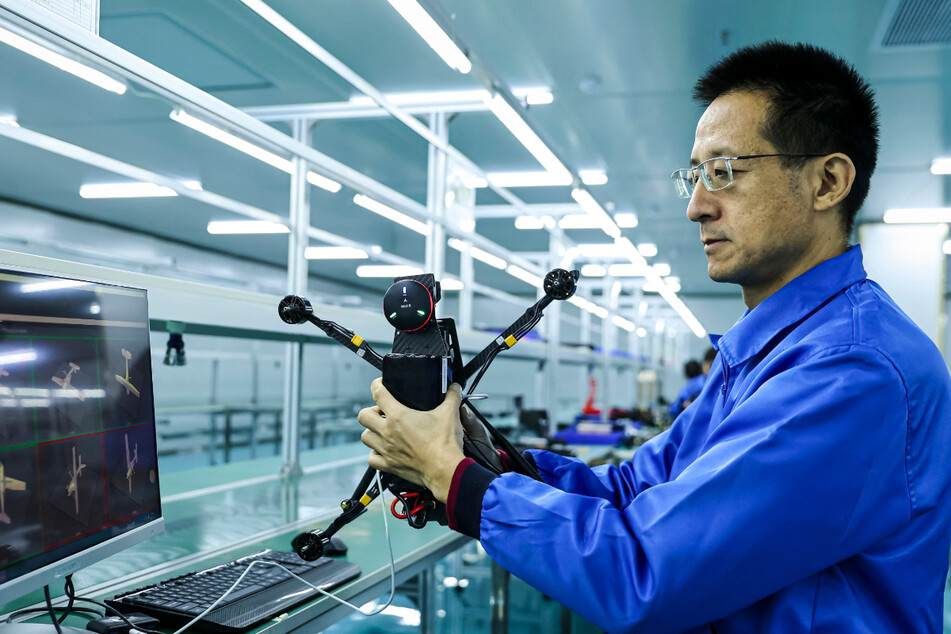 An employee works on a production line of drones intended for export at a factory in Ruichang, in China's eastern Jiangxi province on November 27, 2024.