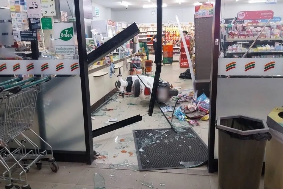 Der weiße Motorroller durchbrach die Glastür des 7-Eleven-Supermarkts.