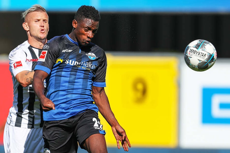 Paderborns Christopher Antwi-Adjej (r) kommt vor Freiburgs Jonathan Schmid an den Ball.