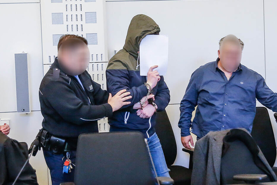 In Handschellen wurden die Angeklagten ins Gericht geführt.