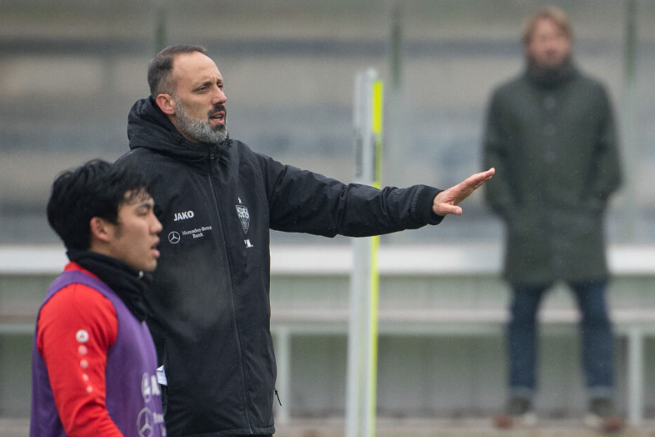Pellegrino Matarazzo (M), Trainer des VfB Stuttgart, gestikuliert neben Wataru Endo (l). Im Hintergrund steht Sven Mislintat, Sportdirektor des VfB Stuttgart.