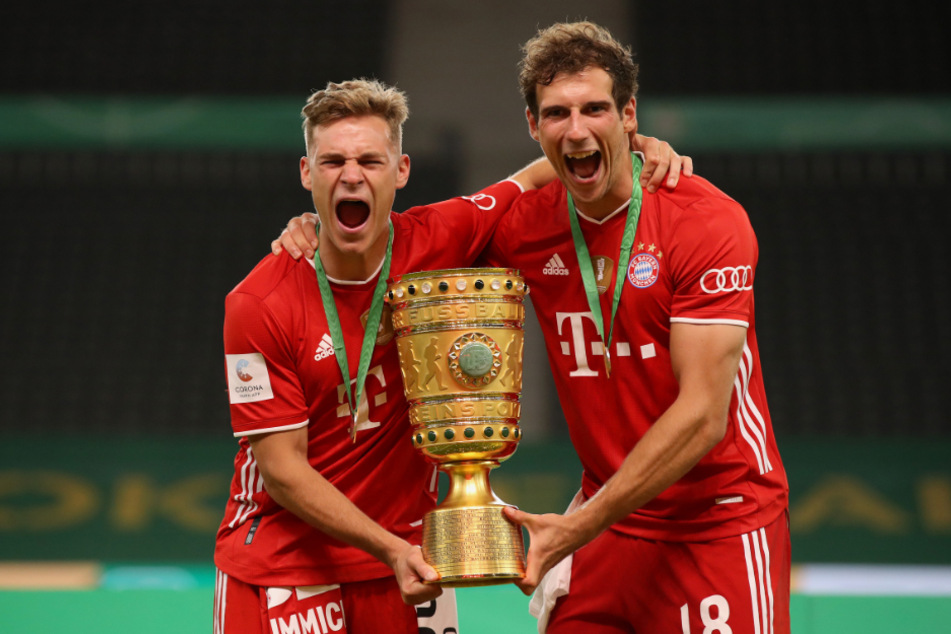 Joshua Kimmich und Leon Goretzka jubeln mit dem Pokal.