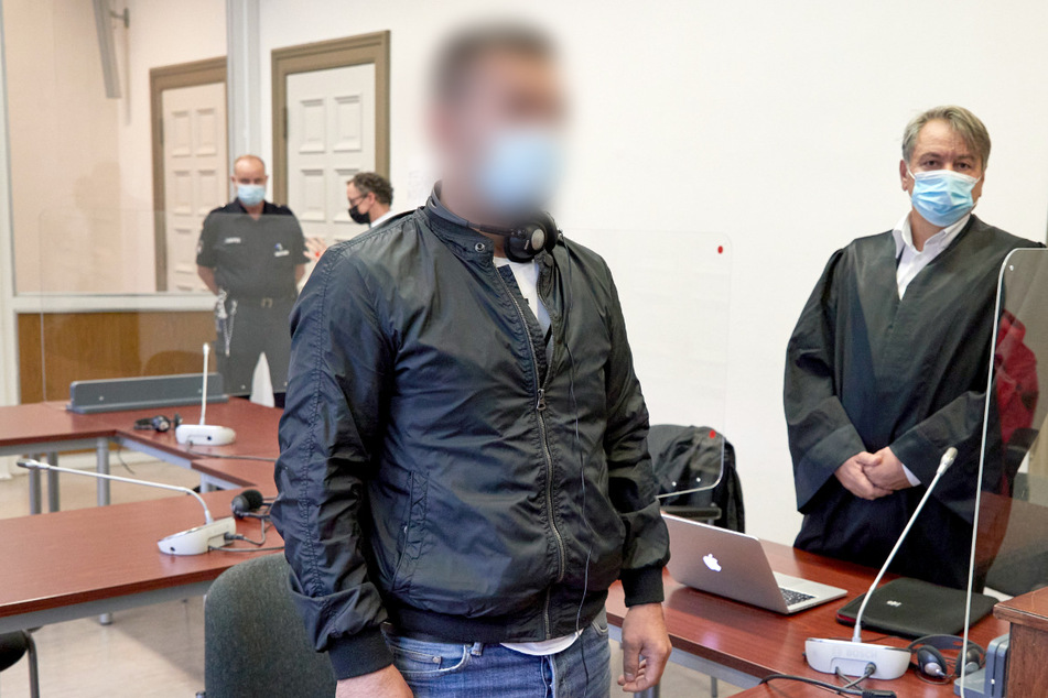 Der Angeklagte (l) steht im Gerichtssaal. Ihm werden zwei Mordversuche an Polizisten vorgeworfen.