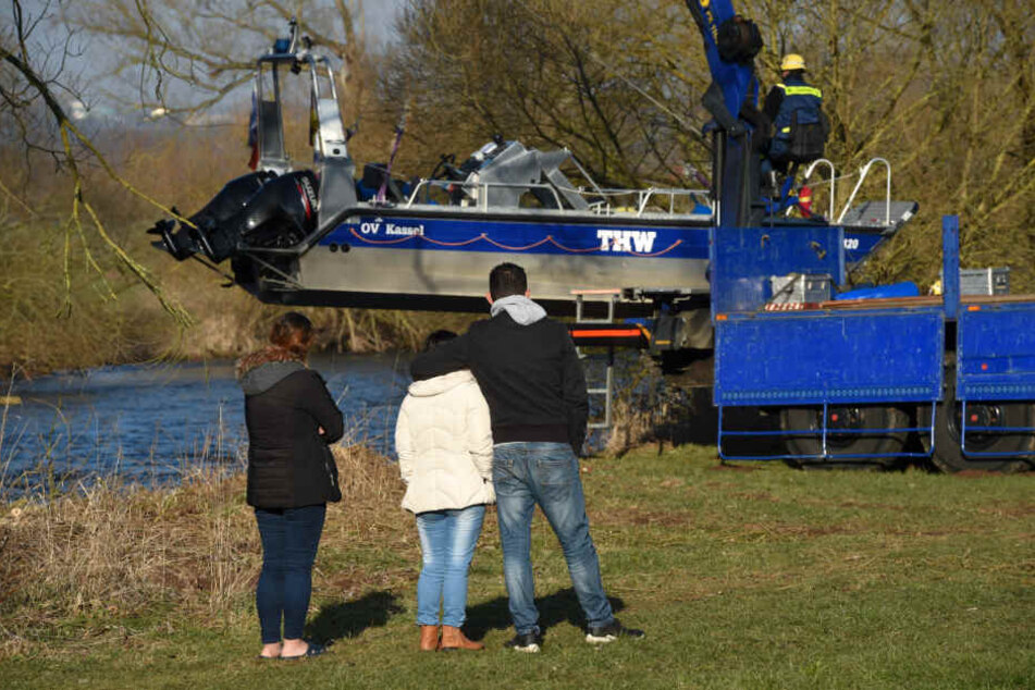 Angehörige stehen vor dem Sonarboot, das gerade ins Wasser gelassen wird.