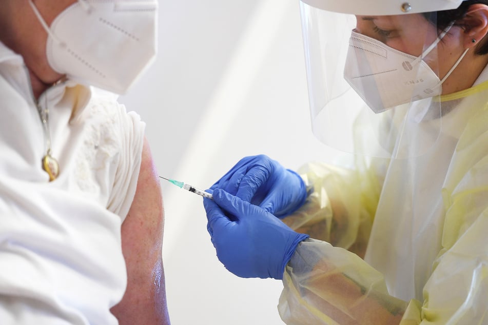 Eine Frau (l) wird von einer Mitarbeiterin eines mobilen Impfteams mit Impfstoff gegen das Coronavirus geimpft.