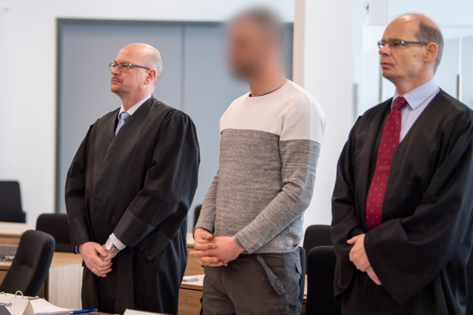 Der wegen Bildung einer terroristischen Vereinigung Angeklagte (M) wartet mit seinen Anwälten Michael Ohlendorf (l) und Patrick Graf zu Stolberg im Gerichtssaal auf den Beginn der Verhandlung.