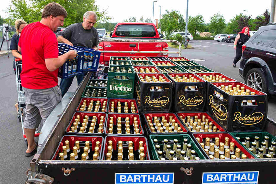 Bierkästen werden auf einen Anhänger geladen.