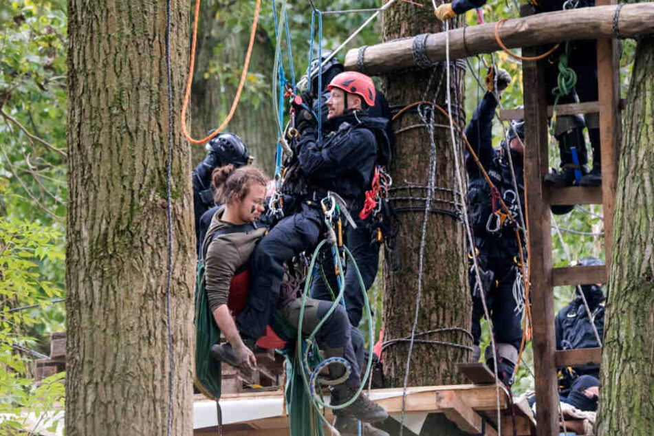 Die Polizei räumte das Camp der Aktivisten. Ein Beamter seilt sich gemeinsam mit einem der Demonstranten ab.