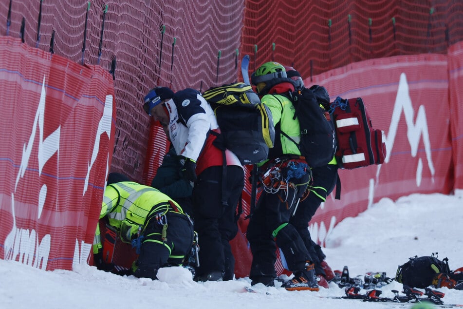 Das Schreckensbild von Freitag: Der französische Ski-Star Cyprien Sarrazin (30) muss schwer verletzt von medizinisches Personal aus dem Fangnetz geborgen werden.