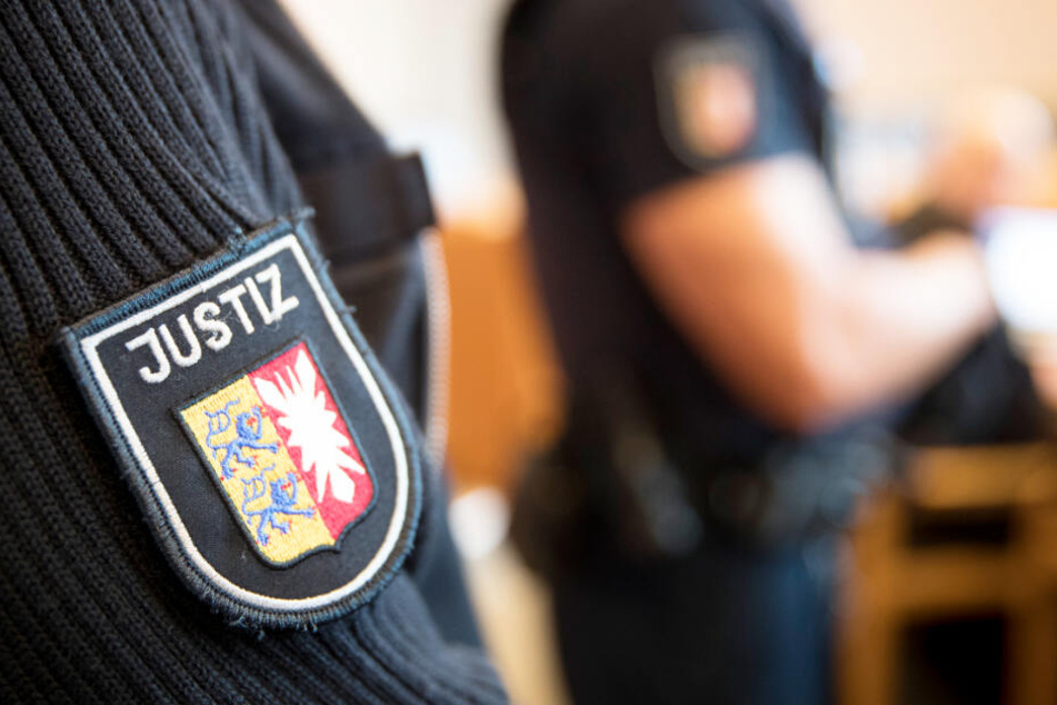 Justizbeamte stehen im Gerichtssaal. (Archivbild)