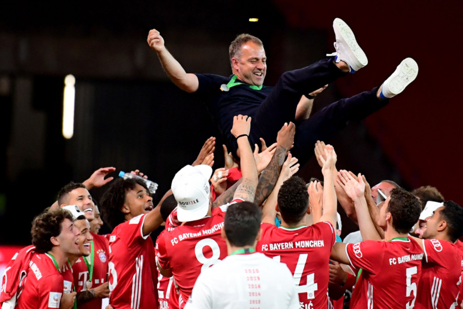 Hansi Flick (55) wird nach dem Erfolg von den Spielern in die Luft geworfen.