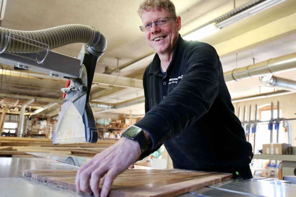 Drechslermeister Jens König legt in seiner Werkstatt ein Parkettmuster aus Merbau-Holz auf, wie es auch auf Schiffen der AIDA-Flotte verlegt wurde.