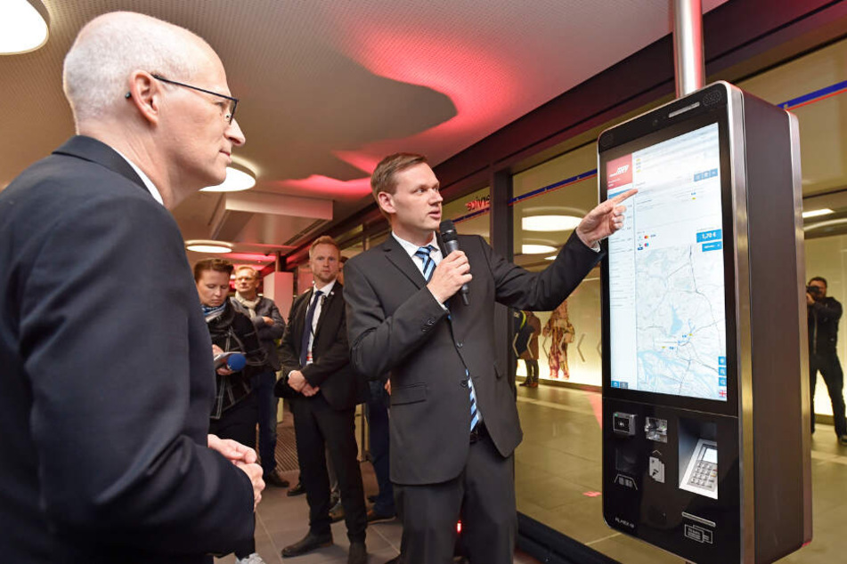 Martin Austen von der Hochbahn zeigt Bürgermeister Peter Tschentscher (SPD) den neuen Fahrkarten-Automaten.