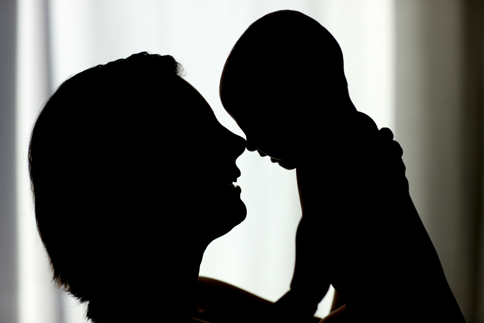 Eine Mutter hält ihr Baby hoch. Mütter mit Corona-Infektion sollten ihre neugeborenen Babys stillen und mit ihnen kuscheln dürfen.