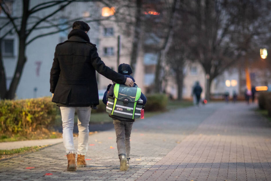 Ein Vater begleitet seinen Sohn auf dem Schulweg. Ein Schlafmediziner hat einen späteren Schulstart für sinnvoll. (Symbolbild)
