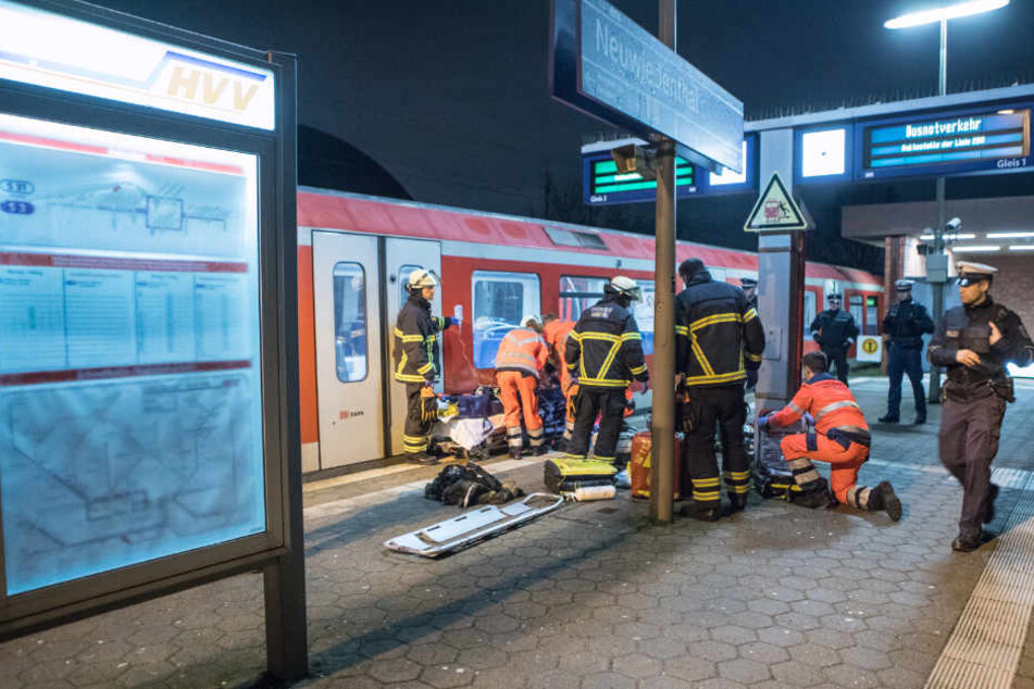 Rettungskräfte versorgen die verletzte Person am Bahnsteig.