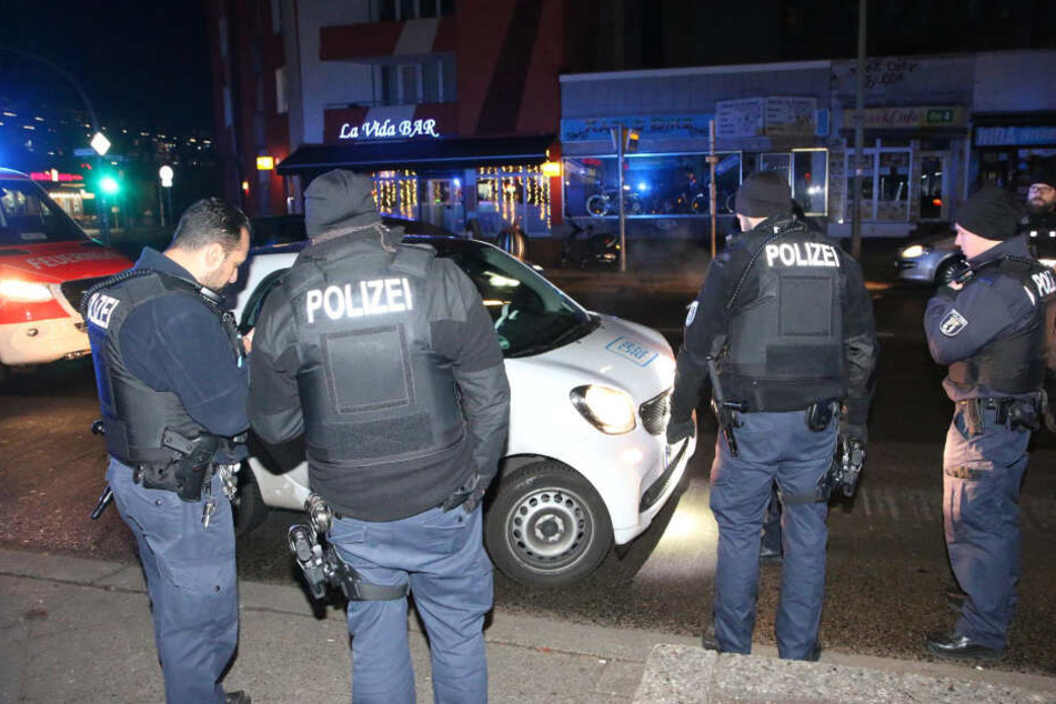 Polizisten stehen vor dem Carsharing-Smart.