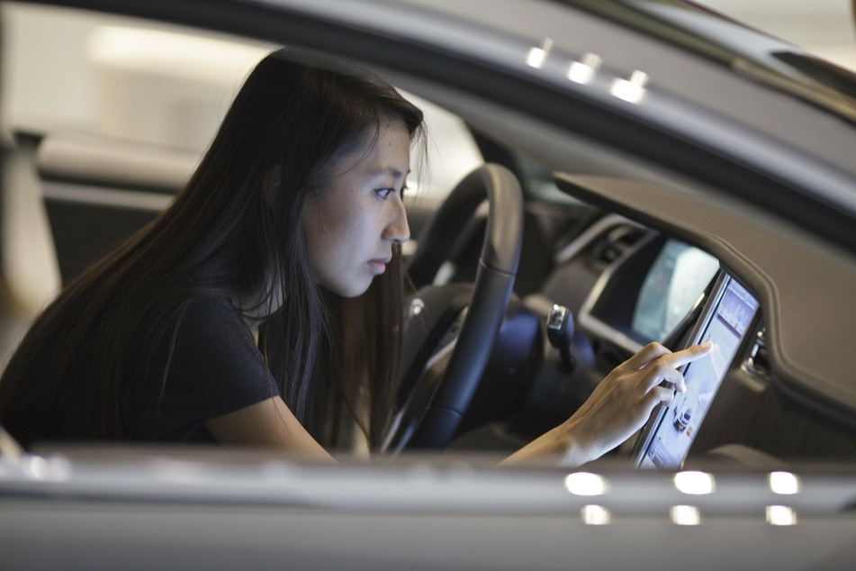 A customer tries out the giant touch screen in a Tesla electric car.