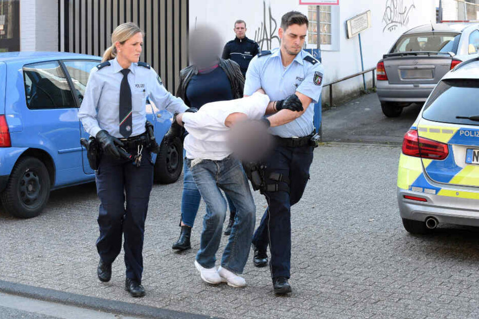 Essen am Freitag: Polizisten führen einen mutmaßlichen Verdächtigen ab. Im Hintergrund eine Zivilfahnderin der Polizei.
