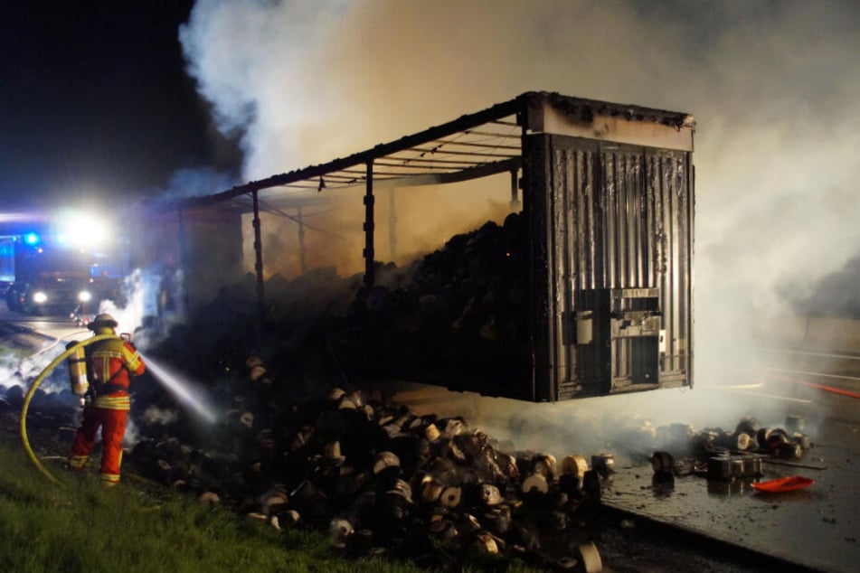 Ein Feuerwehrmann löscht den brennenden Lastwagen.