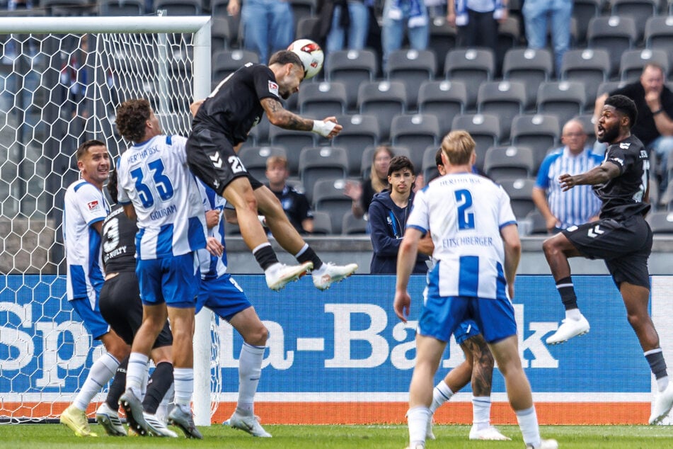 Magdeburgs Falko Michel (oben) antwortet nach einer Ecke.
