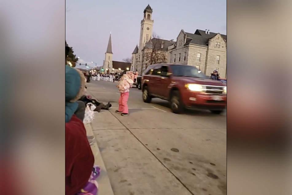 The SUV barely misses a child playing in the street.