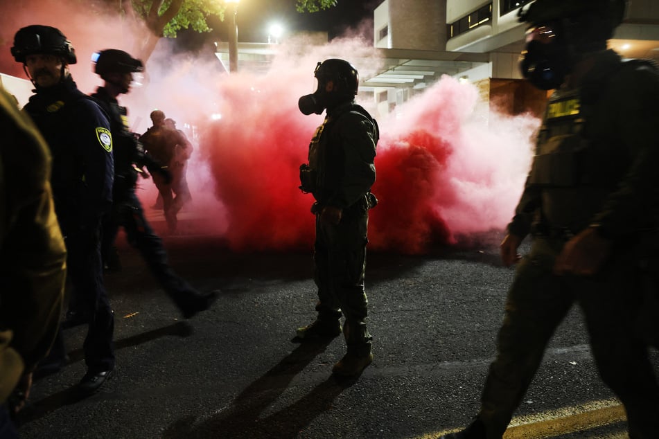 Federal agents and police attempt to keep protesters back outside an ICE facility in downtown Portland, Oregon, on October 5, 2025.