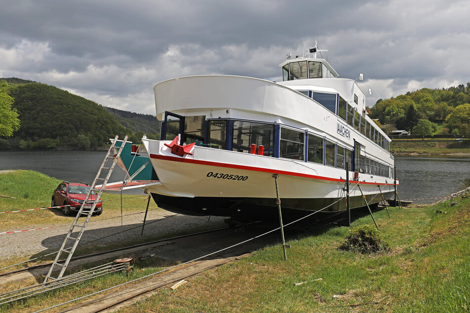 Das Fahrgastschiff "Aachen" liegt am Ufer des Rursees auf dem Trockenen.
