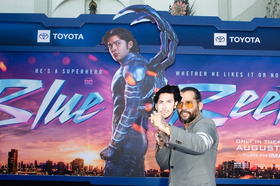 Puerto Rican director Angel Manuel Soto holds a picture of actor Xolo Maridueña as he arrives for Warner Bros' Blue Beetle premiere at the TCL Chinese Theatre on August 15, 2023.