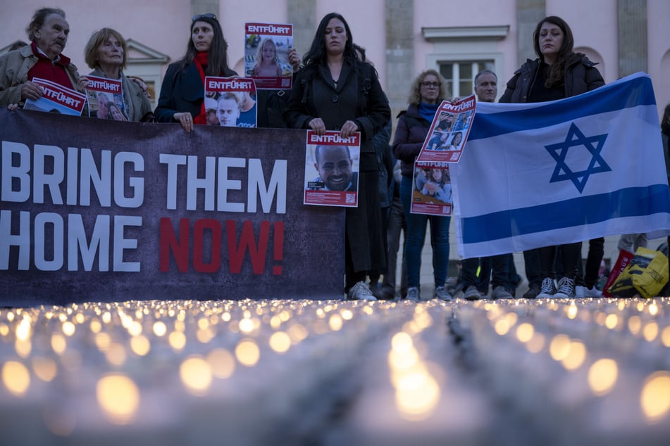 Auch auf dem Berliner Bebelplatz wurde demonstriert: Teilnehmer der Kundgebung des Jungen Forums fordern unter dem Motto "Nie wieder ist jetzt!" die Befreiung der Geiseln der Hamas, während im Vordergrund 1000 Kerzen im Gedenken an die Opfer des Terrorakts brennen.